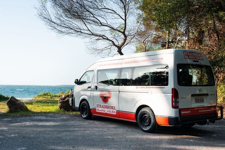 Branded Stradbroke Island Tours minibus parked at a coastal lookout on North Stradbroke Island