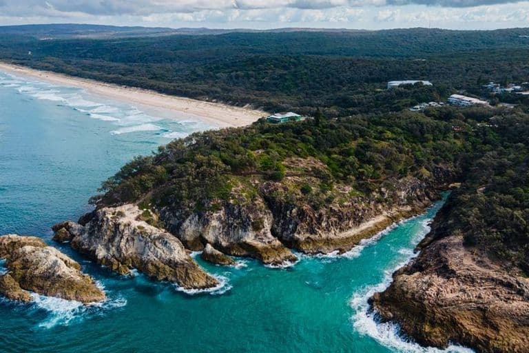 Aerial view of a rocky headland and long sandy beach at North Gorge on North Stradbroke Island